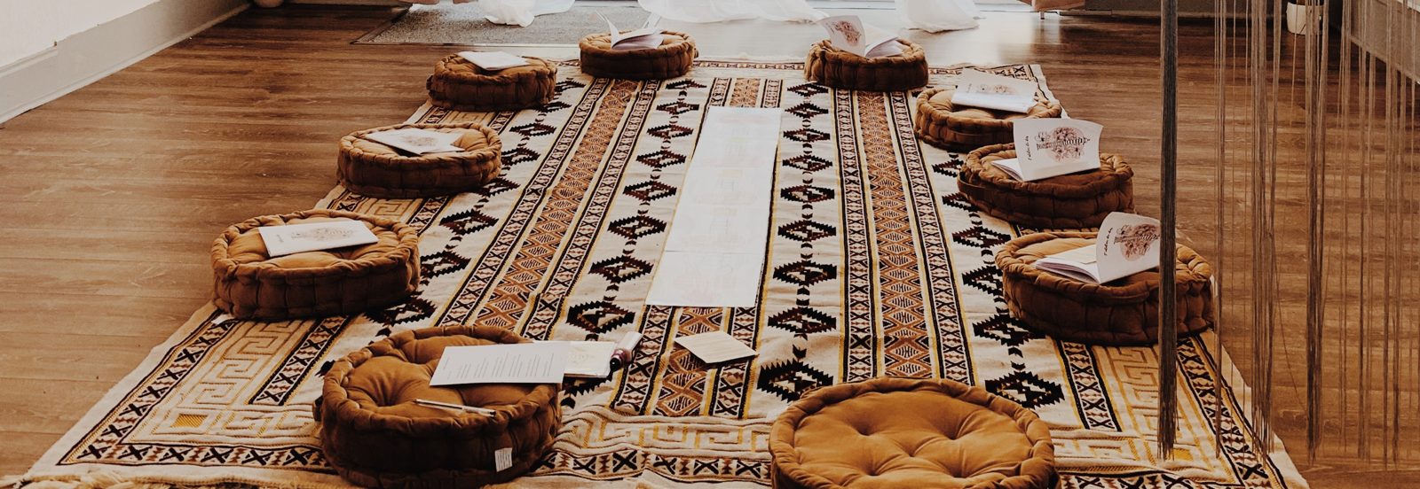 Coussins disposés en cercle sur un tapis dans la salle du studio